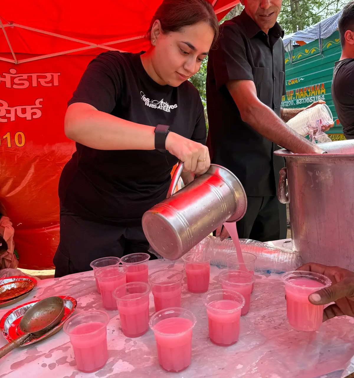 Volunteers serving food and drinks to families at a community meal drive